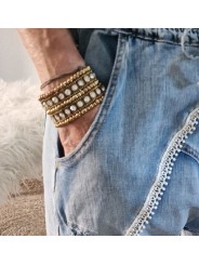 Bracelet élastique serti de pierres cristal, perles et matériaux dorés.
